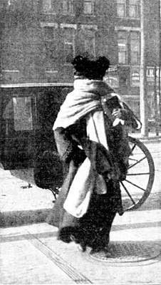 Ellen Terry in a scarf crossing the street